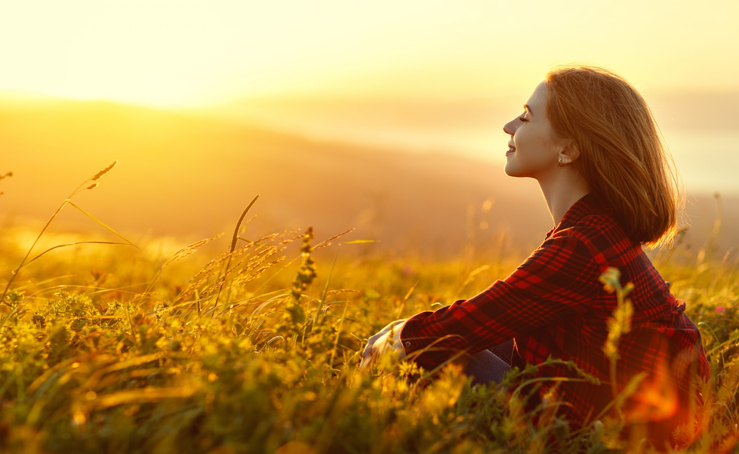 Woman Sits With Her Back In The Field And Admires Woman Sits With Her Back In The Field And Admires