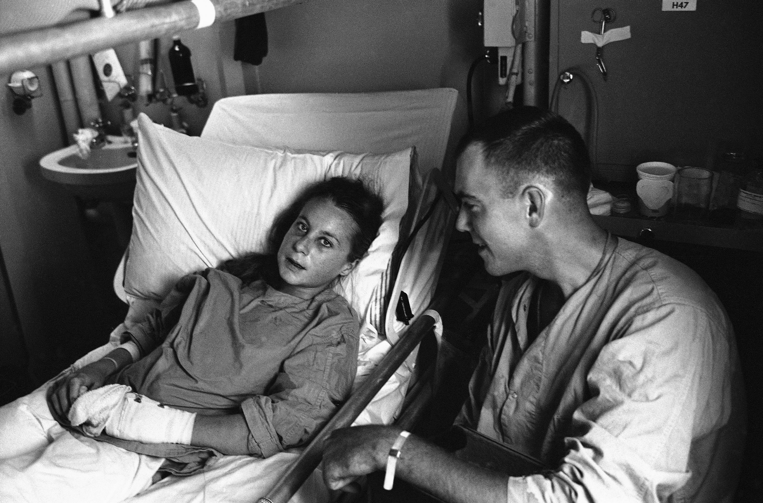 French freelance photographer Catherine Leroy talks with Lt. Robert Brown on May 28, 1967, 23, of New York’s Staten Island from hospital bed aboard hospital ships USS Sanctuary in South China sea off Vietnamese coast. Both were wounded by same North Vietnamese mortar blast on May 19. She was photographing U.S. Marines moving toward the demilitarized zone at the time. Brown was first man to reach Catherine, and despite his own arm wound, gave her first aid and brought her out of the battlefield. She suffered multiple shrapnel wounds and a fractured jaw. (AP Photo)